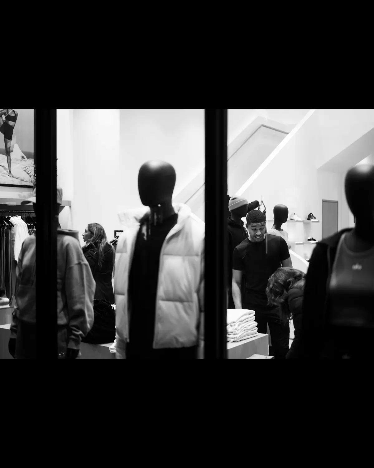 Vitrine d’une boutique de mode, mannequins et clients à l’intérieur